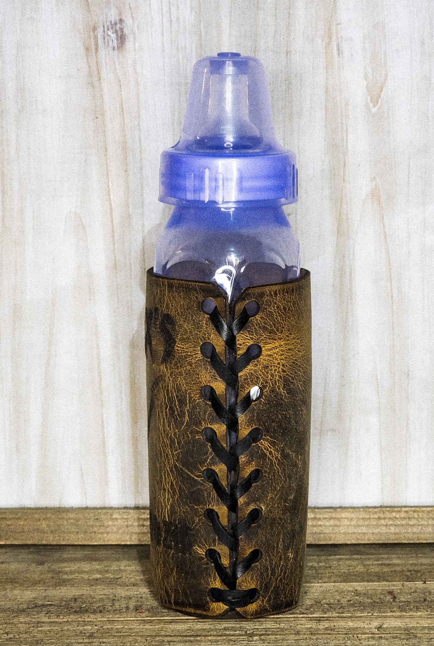 Side view of personal leather wrapped baby bottle koozie with baseball stitching baby shower gifts for boys