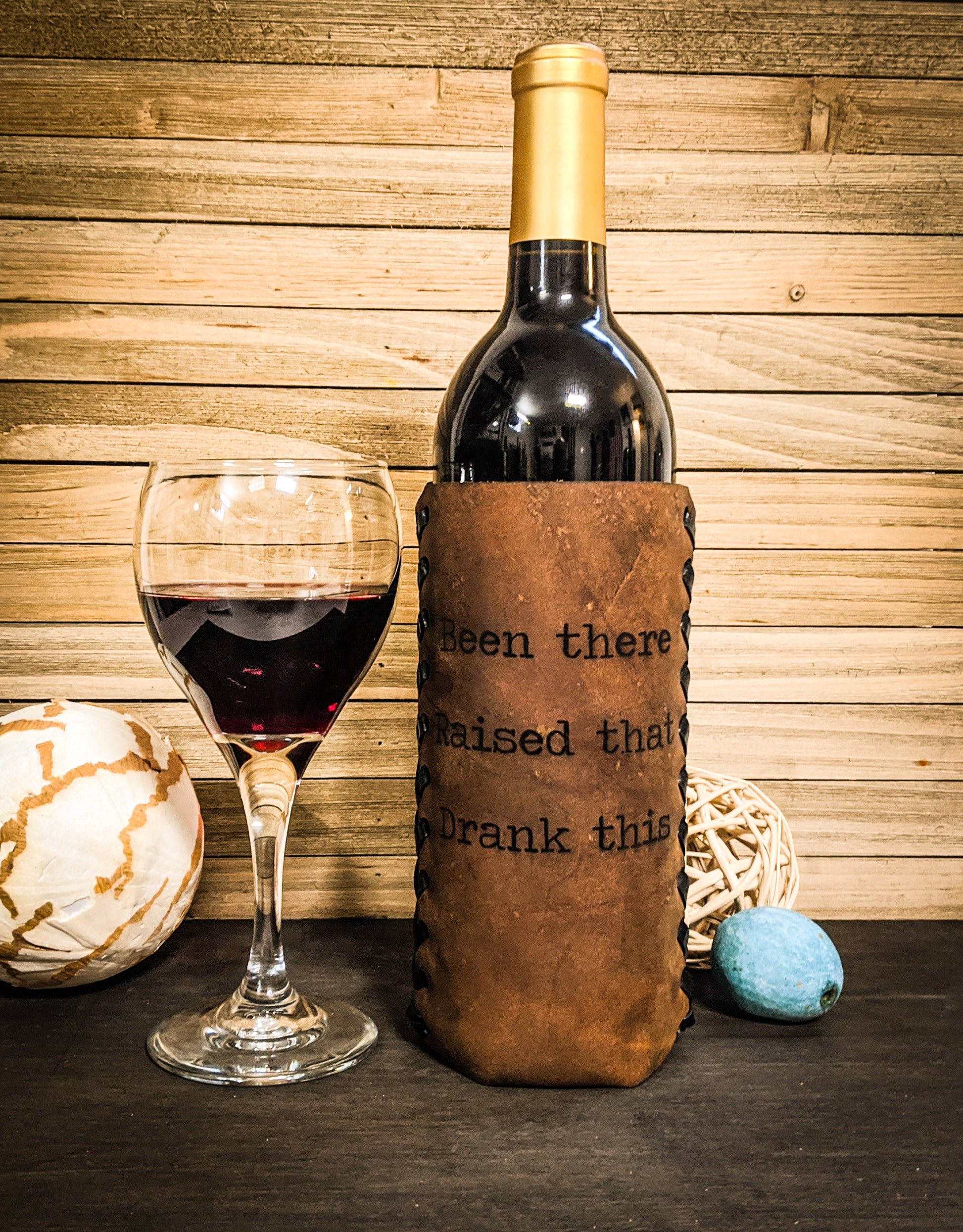 Leather wrapped wine bottle with hand lacing in Brown with saying "been there raised that" 3-year wedding anniversary gift for a woman