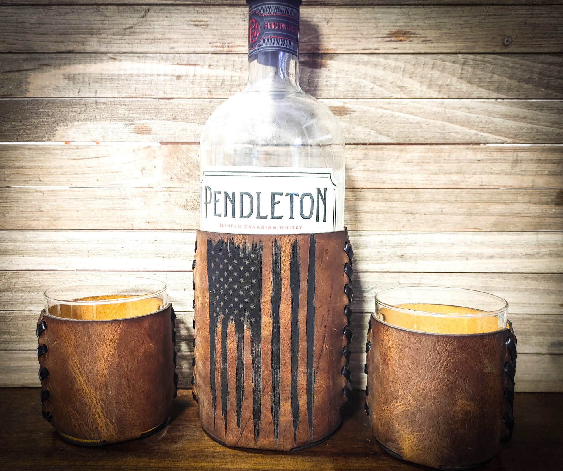 Vertical worn American flag whiskey bottle koozie with two leather wrapped glasses around Pendleton liquor bottle birthday gift for men